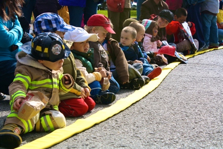 Kids lined up by a fire hose