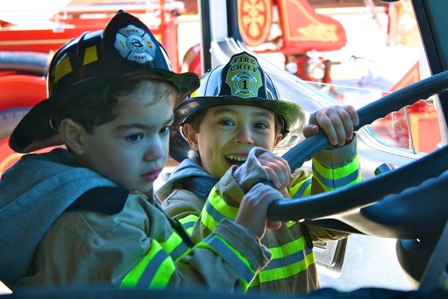 Little kids dressed up as fire fighters,